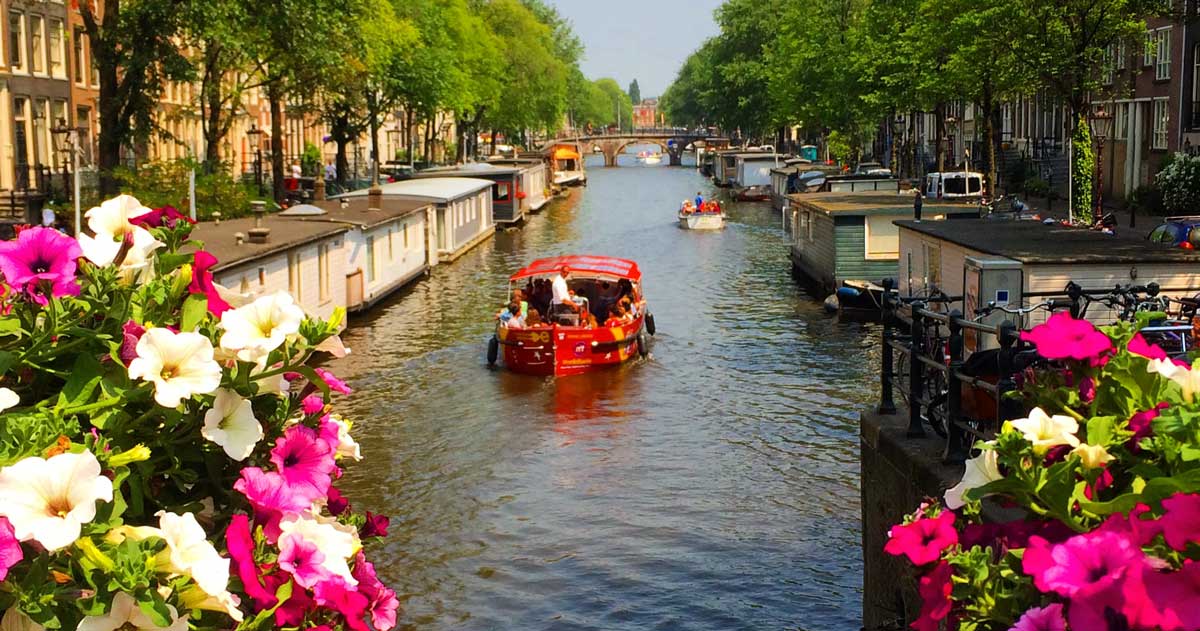 Um barco passeando pelos canais de Amsterdam no verão